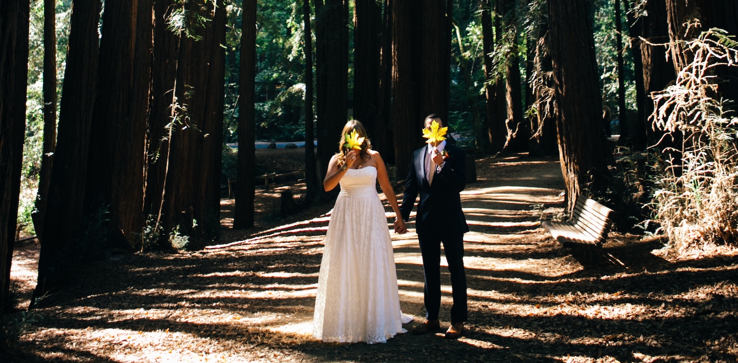 Bride and Groom in the forest with leaf in front of their faces